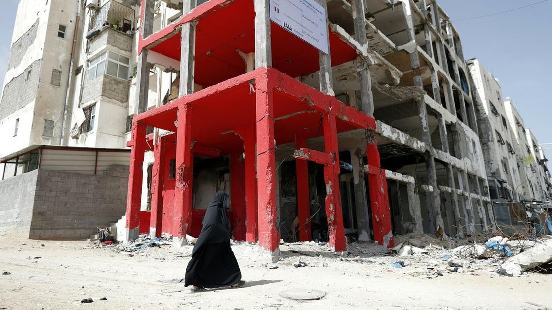 A Palestinian veiled woman walks past a building which was destroyed during the 50-day war between Israel and Hamas-led militants in the summer of 2014, in the northern Gaza Strip city of Beit Hanun, on May 9, 2016. THOMAS COEX / AFP