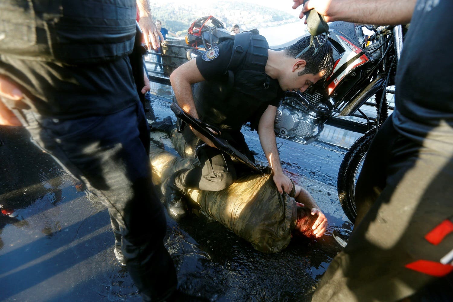 A policeman checks a slodier beaten by the mob after troops involved in the coup attempt surrendered on the Bosphorus Bridge in Istanbul. (Reuters)