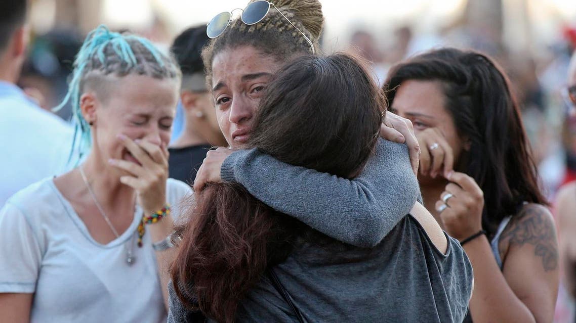 People comfort each other at a makeshift memorial to honor the victims of an attack near the area where a truck mowed through revelers on the famed Promenade des Anglais in Nice, southern France, Sunday, July 17, 2016 (Photo: AP)