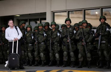 A passenger waits as Brazilian Air force soldiers patrol the Tom Jobim International airport ahead of the 2016 Rio Olympics in Rio de Janeiro, Brazil, July 19, 2016. REUTERS
