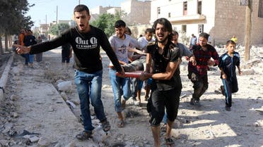 Syrians carry a stretcher as they evacuate victims from the rubble of a collapsed building following a reported air strike on the rebel-held neighbourhood of Sakhur in the northern city of Aleppo. (AFP)