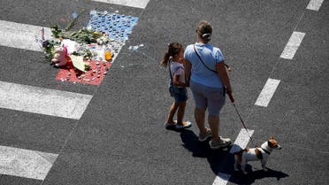 A woman and a child stand near a makeshift memorial placed on the road during a minute of silence on the third day of national mourning to pay tribute to victims of the truck attack along the Promenade des Anglais in Nice. (Reuters)