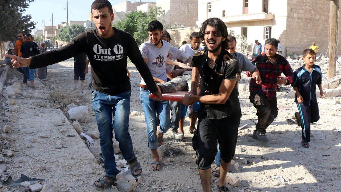 Syrians carry a stretcher as they evacuate victims from the rubble of a collapsed building following a reported air strike on the rebel-held neighborhood of Sakhur in Aleppo on July 19, 2016. (AFP)
