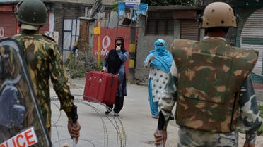 Indian paramilitary troopers stand guard as Kashmiri women approach them on the 14th day of a curfew in downtown Srinagar on July 22, 2016. (AFP)