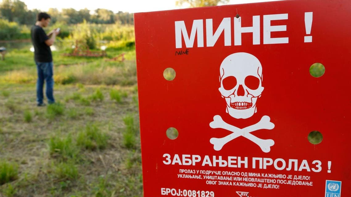 A Bosnian man plays Pokémon Go on his phone in a minefield near the Bosnian town of Brcko. (AP)