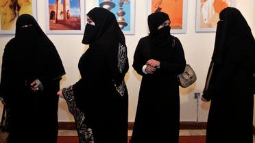 A group of Saudi women look at photographs by a group of Saudi women photographers during the opening of their gallery in Amman April 8, 2009. REUTERS