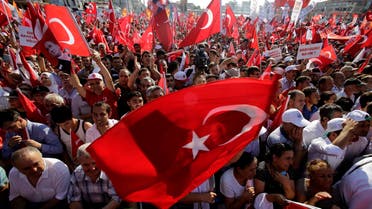 A supporter of the Republican People's Party, or CHP, waves a Turkish flag bearing a portrait of Mustafa Kemal Ataturk, the founder of modern Turkey, during a 'Republic and Democracy Rally' at Taksim square in central Istanbul, Sunday, July 24, 2016. Thousands of supporters of Turkey's main opposition group and some ruling party members rallied in Istanbul to denounce a July 15 coup attempt, a rare show of political unity that belied opposition unease over President Recep Tayyip Erdogan's crackdown since the failed uprising. (AP Photo/Petros Karadjias)
