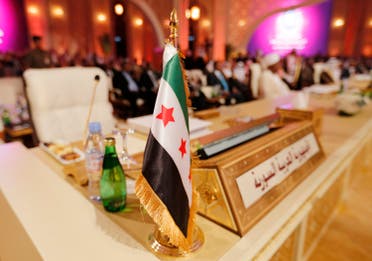 The Syrian opposition flag is seen in front of the seat of the Syrian delegation at the opening the Arab League summit in Doha March 26, 2013. (Reuters)