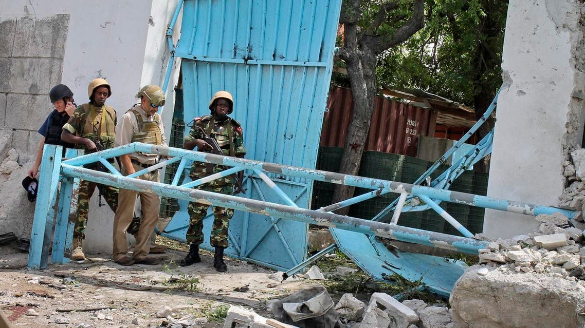 African Union peacekeepers and unidentified foreigners stand outside the main U.N. compound, following an attack on it in Mogadishu, Somalia Wednesday, June 19, 2013. Al-Qaida-linked militants detonated multiple bomb blasts and engaged in ongoing battles with security forces in an attempt to breach the main U.N. compound in Mogadishu, officials said Wednesday. (AP)