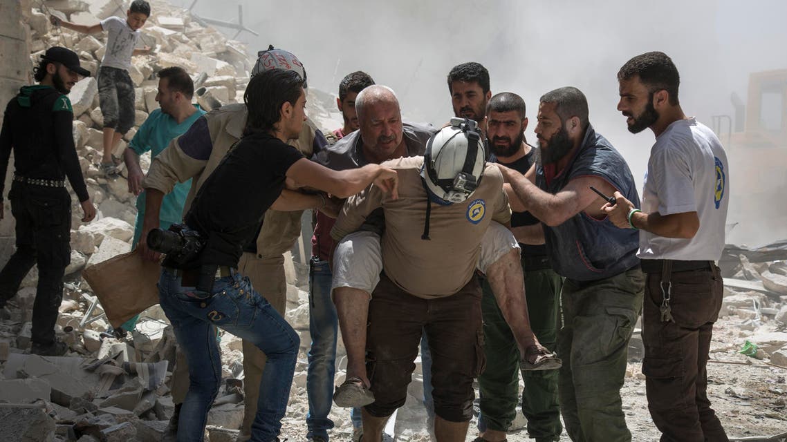 Syrians carry a wounded man away from the rubble of a building that according to the Syrian Observatory for Human Rights was destroyed during a barrel bomb attack by government forces near Aleppo on July 26, 2016. (AFP)