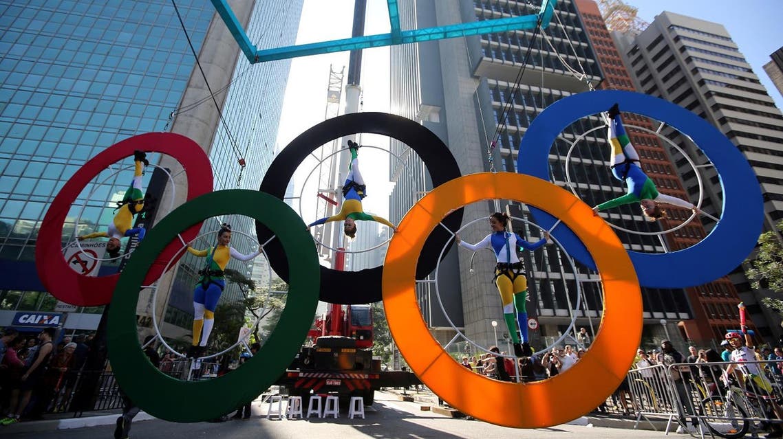 Acrobats perform on the Olympics rings at Paulista Avenue in Sao Paulo's financial center, Brazil, July 24, 2016. REUTERS/Paulo Whitaker