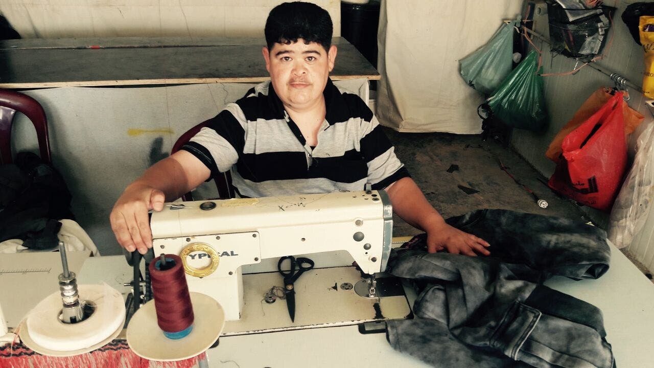 Shaker al-Omary came to Zaatari three years ago, where he set up this tailor shop named after his hometown Daraa al-Balad. (UNICEF/MENA/Dakhlallah)