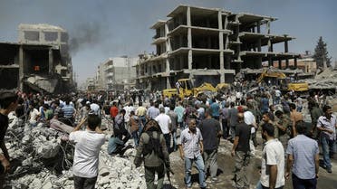 Syrians gather at the site of a bomb attack in Syria's northeastern city of Qamishli on July 27, 2016. (AFP)