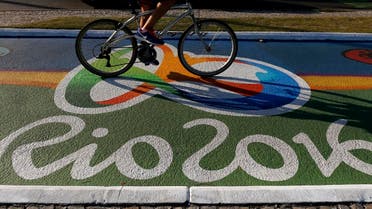 A woman rides her bicycle as she passes over a newly-painted bicyle lane ahead of the Rio 2016 Olympic games near Barra da Tijuca beach in Rio de Janeiro, Brazil, July 27, 2016. REUTERS/