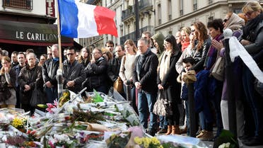 People observe a minute of silence on November 16, 2015 at the Le Carillon cafe at the corner of Rue Bichat and Alibert in the 10th arrondissement and "Le petit Cambodge" restaurant at the site of the attacks in Paris, to pay tribute to victims of the attacks claimed by Islamic State which killed at least 129 people and left more than 350 injured on November 13. AFP PHOTO / ERIC FEFERBERG 
