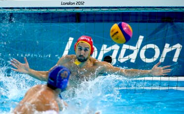 Serbia's Filip Filipovic, bottom, scores on a penalty against Montenegro goalkeeper Milos Scepanovic during the men's water polo bronze medal match at the 2012 Summer Olympics, Sunday, Aug. 12, 2012, in London. (AP