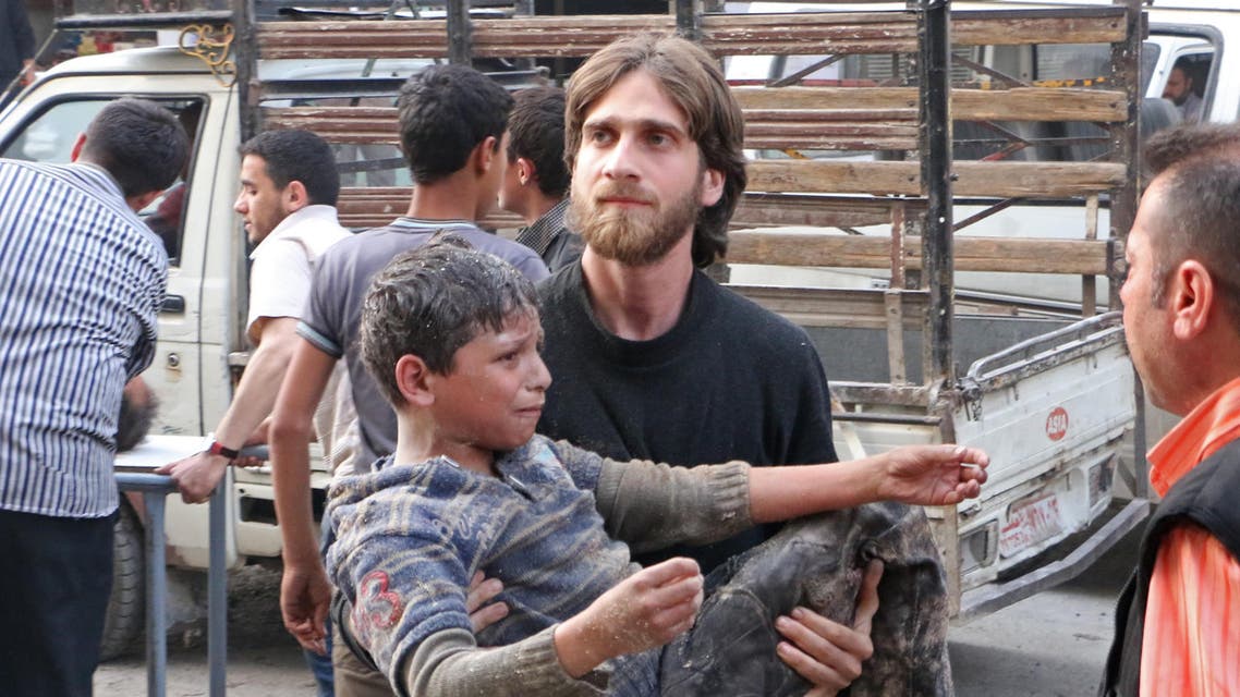 A rebel fighter carries a wounded child following a reported air strike by pro-regime forces on the village of Atareb in the northern Syrian province of Aleppo, on April 24, 2014. AFP