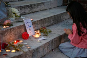 A young girls prays near flowers and candles at the town hall in Saint-Etienne-du-Rouvray, near Rouen in Normandy, France, to pay tribute to French priest, Father Jacques Hamel, who was killed with a knife and another hostage seriously wounded in an attack on a church that was carried out by assailants linked to ISIS, July 26, 2016. (Reuters)