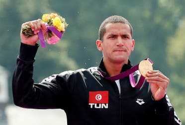 Tunisia's Oussama Mellouli poses with his gold medal after the men's 10km marathon swimming at Hyde Park during the London Olympic Games August 10, 2012. (Reuters)