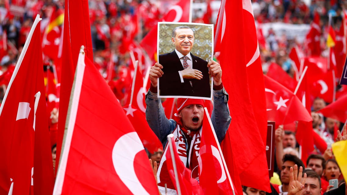 A supporter of Turkish President Tayyip Erdogan holds up a picture during a pro-government protest in Cologne, Germany July 31, 2016. REUTERS