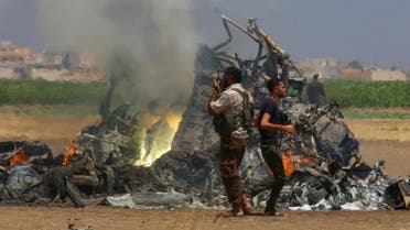 Men inspect the wreckage of a Russian helicopter that had been shot down in the north of Syria's rebel-held Idlib province, Syria August 1, 2016. REUTERS