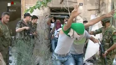 This still image from Syrian state TV video, shows young men with their faces covered surrendering to government forces, in Aleppo, Syria, Saturday, July 30, 2016, Syrian state media is reporting that dozens of families have started leaving besieged rebel-held neighborhoods in the northern city of Aleppo after the government opened safe corridors for civilians and fighters who want to leave. The Russian military says 169 civilians have left through the corridors since they were set up, but Syrian opposition activists say no civilians have left besieged parts of the city. (Syrian State TV, via AP)