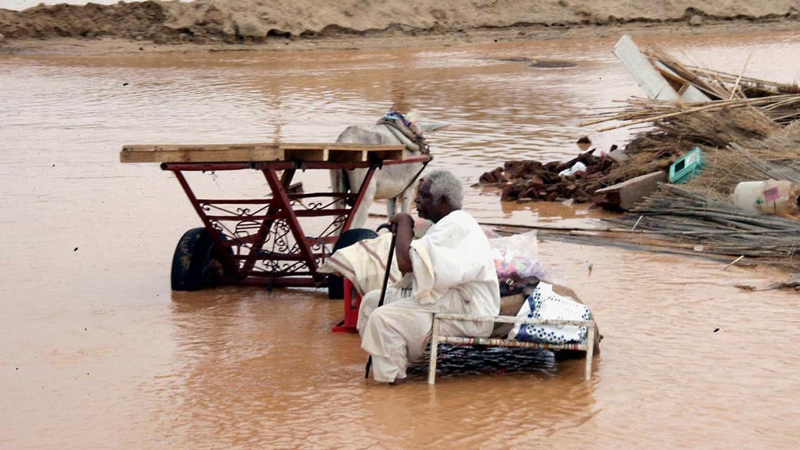 A Sudanese sits amongst the remains of his home following floods in Kassala, near Khartoum, Sudan.(AP)
