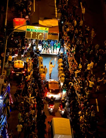 The Olympic torch is carried through the streets of Copacabana as the torch relay continues on its journey to the opening ceremony of the 2016 Summer Olympics in Rio de Janeiro, Brazil, early Friday, Aug. 5, 2016. (AP)