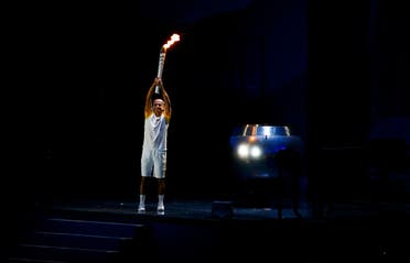 Former Brazilian marathon runner Vanderlei Cordeiro de Lima holds the Olympic torch before lighting the Olympic cauldron at the opening ceremony. REUTERS