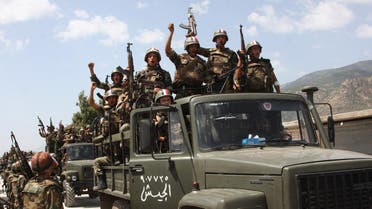 In this June 10, 2011, file photo, taken during a government-organised visit for media, Syrian army soldiers standing on their military trucks shout slogans in support of Syrian President Bashar Assad ap