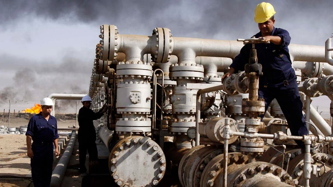 FILE - In this Dec. 13, 2009 file photo, Iraqi laborers work at the Rumaila oil refinery in Zubair near the city of Basra, Iraq. Across a Mideast fueled by oil production, low global prices have some countries running on empty and scrambling to cover shortfalls, even as more regional crude is on tap to enter the market.(AP Photo/Nabil al-Jurani, File)