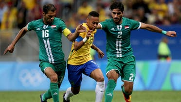 Saad Luaibi (IRQ) (L) of Iraq and teammate Ahmed Ibrahim defend against Neymar (BRA) (C) in the first half. (Reuters)