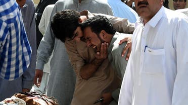 Pakistani local journalists react over the body of a news cameraman after a bomb explosion at a government hospital premises in Quetta. (AFP)