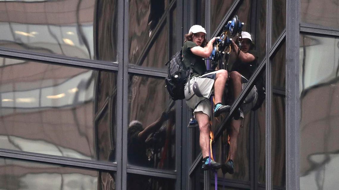 A man scales the all-glass facade of Trump Tower using suction cups Wednesday, Aug. 10, 2016, in New York