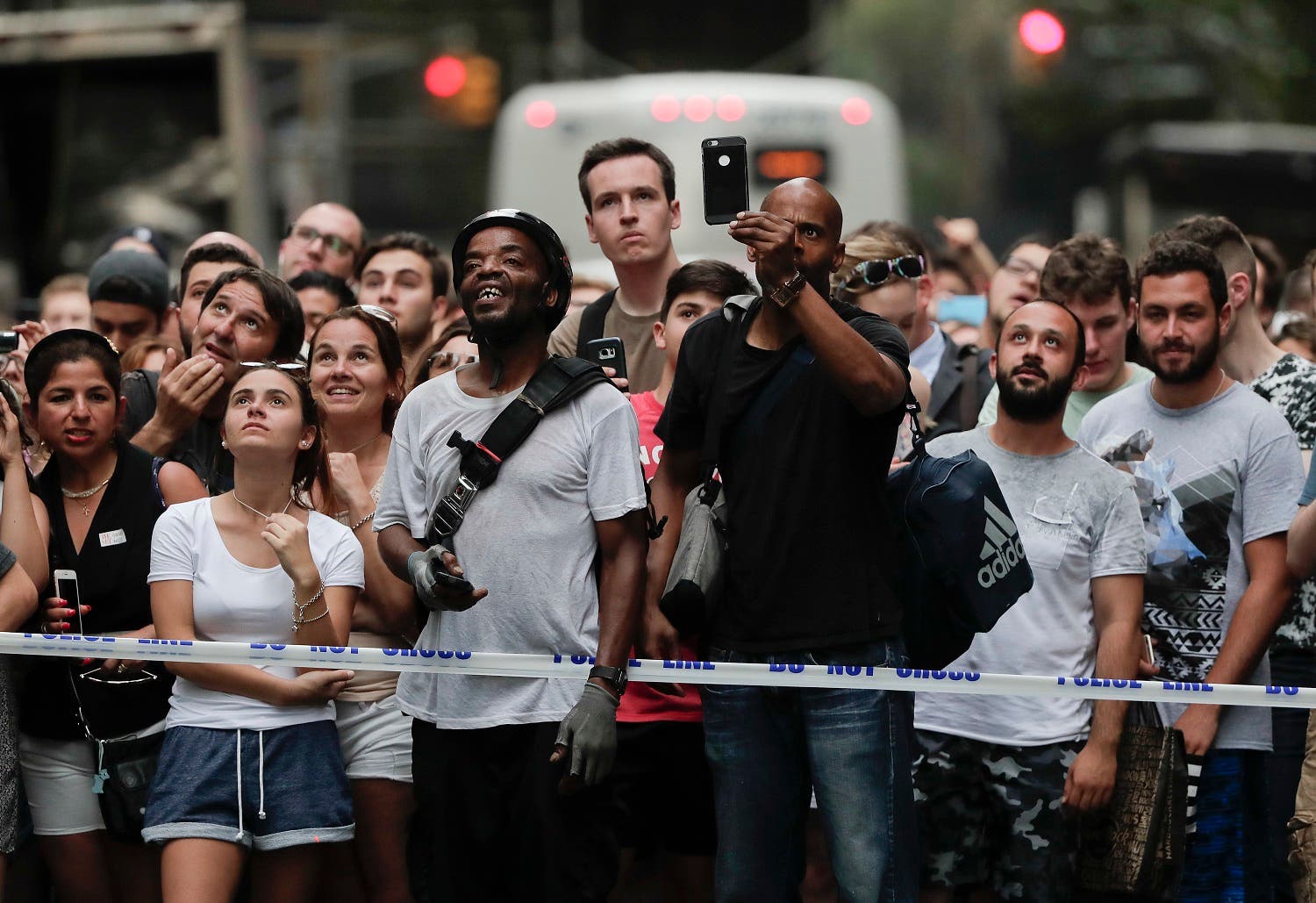 Pedestrians stop to watch as a man scales the all-glass facade of Trump Tower
