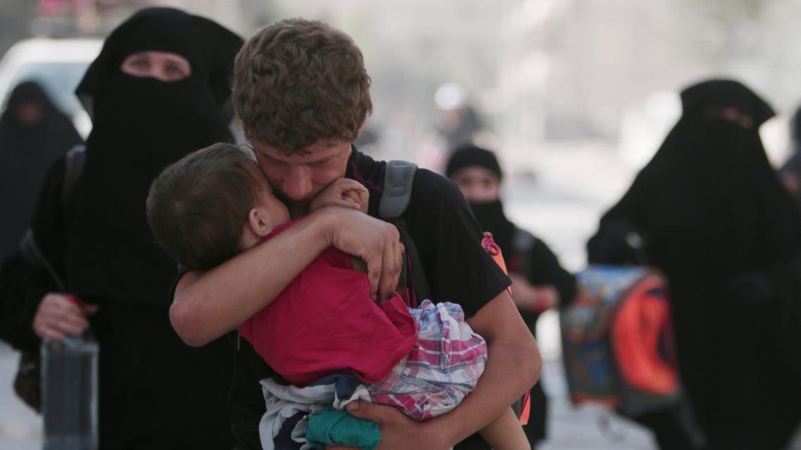 A civilian carries a child as he walks with others after they were evacuated by the Syria Democratic Forces (SDF) fighters from an Islamic State-controlled neighbourhood of Manbij, in Aleppo Governorate, Syria, August 12, 2016. Reuters