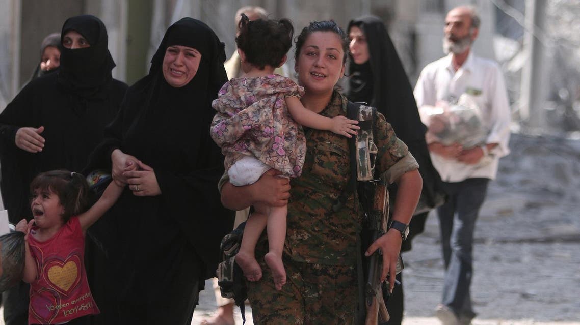 A Syria Democratic Forces (SDF) fighter helps civilians who were evacuated by the SDF from an Islamic State-controlled neighbourhood of Manbij, in Aleppo Governorate, Syria, August 12, 2016. The SDF has said Islamic State was using civilians as human shields. REUTERS