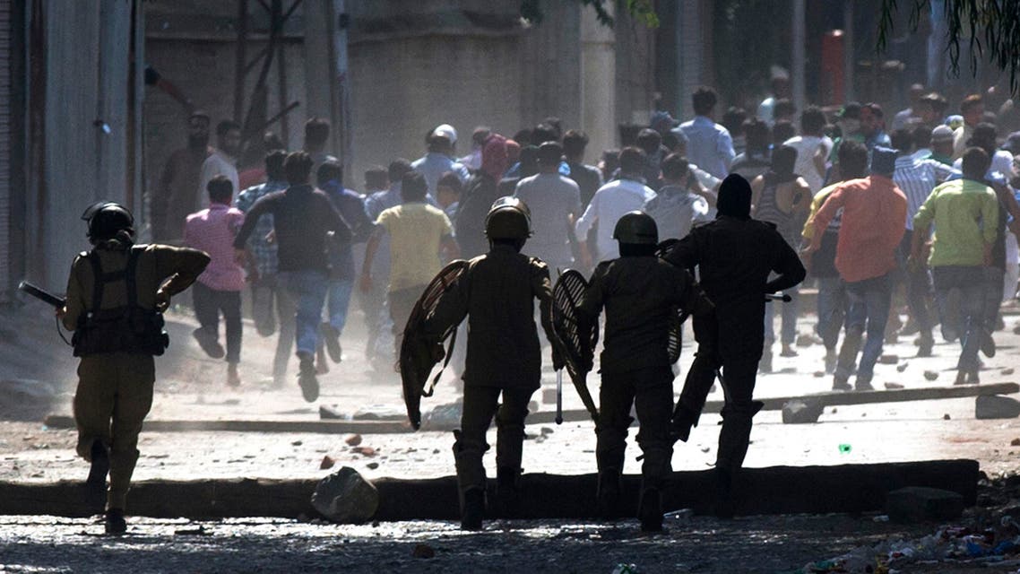 Indian policemen chase Kashmiri protesters in Srinagar, Indian-controlled Kashmir Friday, Aug. 12, 2016. AP