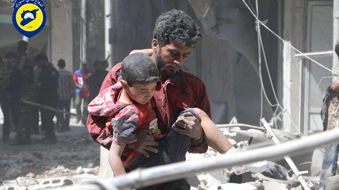 In this file photo taken on May 31, 2016 provided by the Syrian Civil Defense Directorate in Liberated Province of Aleppo, which has been authenticated based on its contents and other AP reporting, shows Syrian man carries an injured boy, in Aleppo, Syria. ap