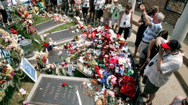 Fans visit the flower-covered grave of Elvis Presley 2007, AP