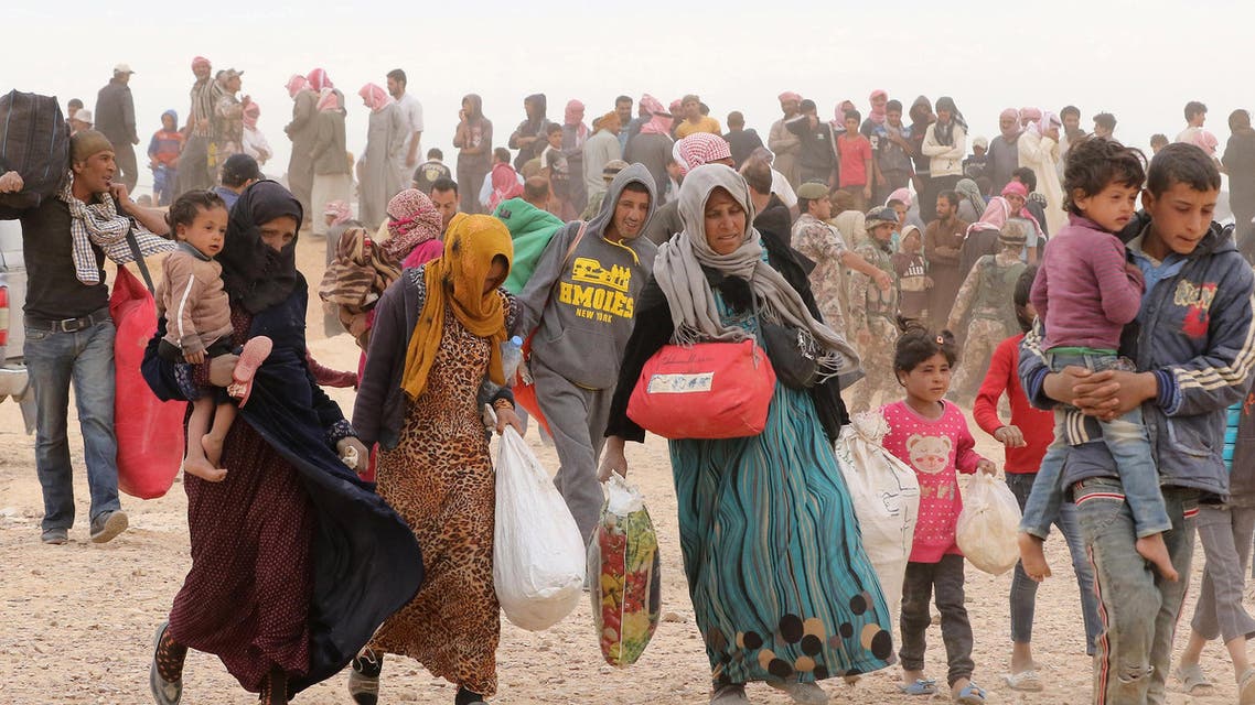 Syrian refugees carry their belongings as they wait to enter Jordanian side of the Hadalat border crossing, a military zone east of the capital Amman, after arriving from Syria on May 4, 2016. According to the Jordanian Commander of the Border Guards Brigadier Saber Al-Mahayreh, around 5000 Syrians fleeing from recent attacks on the northern Syrian city of Aleppo are trying to cross into Jordan in search of safety and most are exhausted and desperately in need of help and medical treatment. AFP
