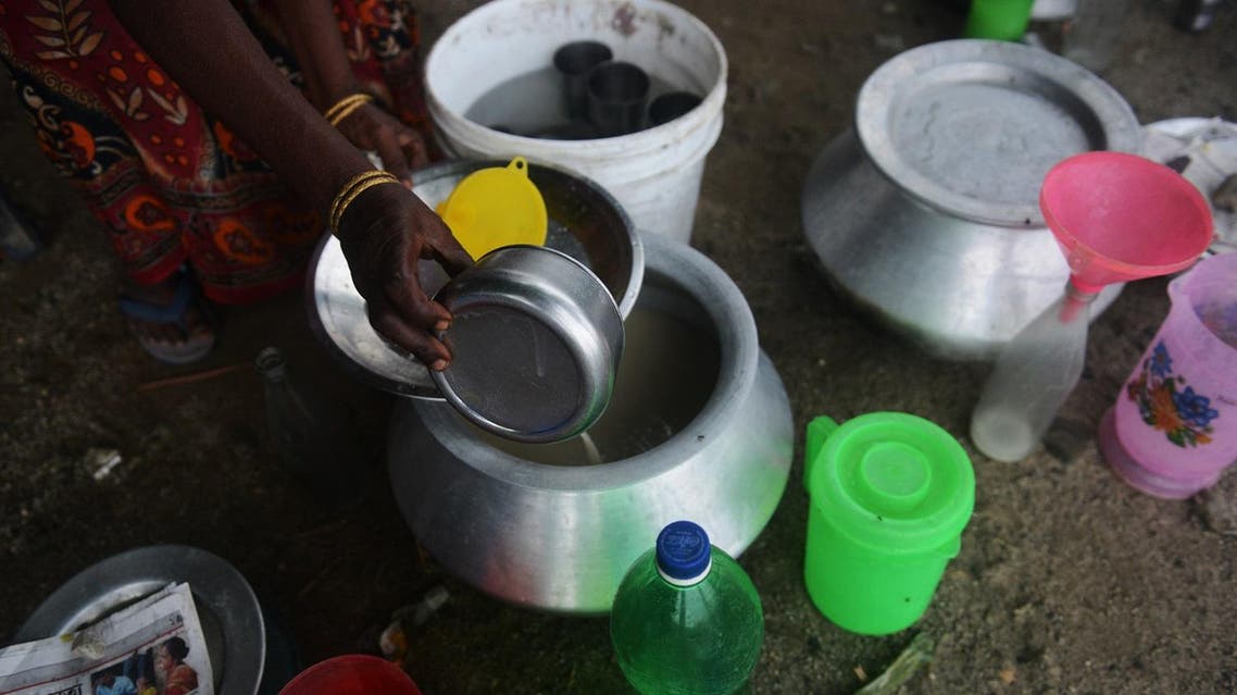 An Indian villager waits for customers at a roadside stall selling locally-brewed alcohol on the outskirts of Siliguri on June 23,2015. 'Haria' is an alcoholic beverage made from rice. AFP PHOTO / DIPTENDU DUTTA DIPTENDU DUTTA / AFP
