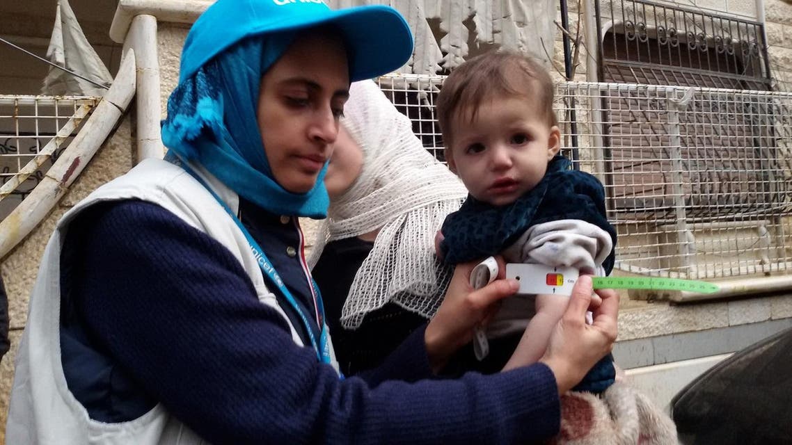 A UNICEF employee measuring the arm of a malnourished child in the besieged Syrian town of Madaya. (File photo: AFP)
