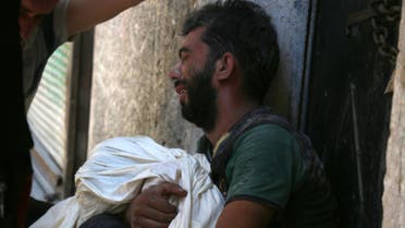 A Syrian man mourns the death of a child following reported air strikes on July 16, 2016 in the rebel-controlled neighbourhood of Saleheen in the northern Syrian city of Aleppo. AFP