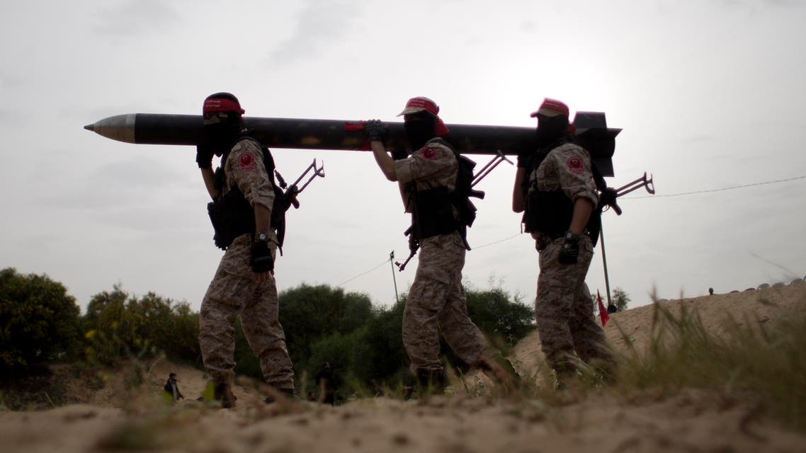 Palestinian militants carry a defused home-made rocket after taking part in a joint military training of the National Resistance brigades and the Abdel Qader al-Husseini brigades on March 25, 2016, in Khan Yunis in the southern Gaza Strip. AFP