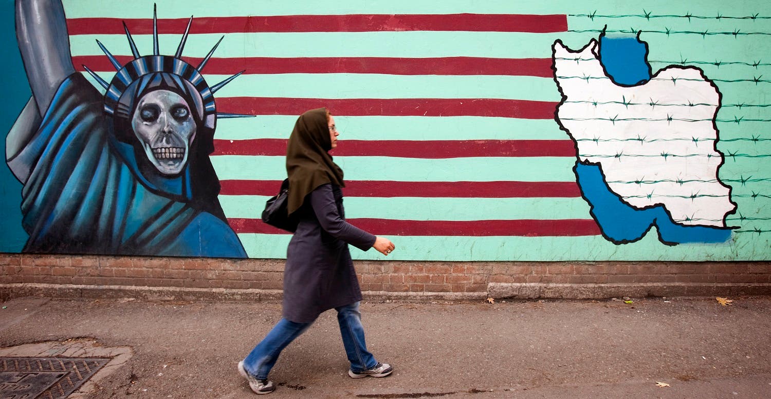 A woman walks past an anti U.S. mural at the former U.S. embassy in Tehran. (Reuters)