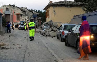 People stand along a road following a quake in Amatrice. (Reuters)
