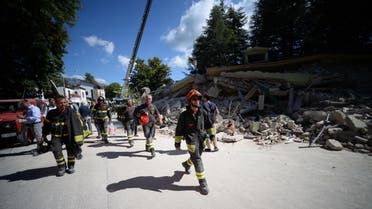 Firefighters walk past a damaged house in the central Italian village of Amatrice. (AFP)
