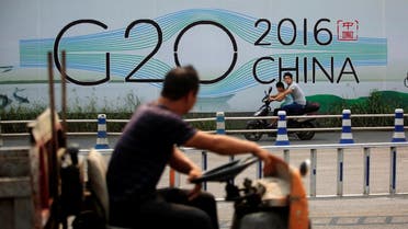 People cycle past a billboard for the upcoming G20 summit in Hangzhou. (Reuters)