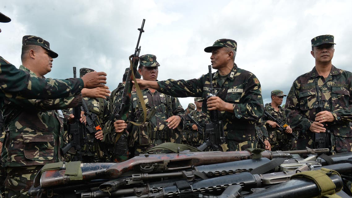 Philippine military officers hand over newly acquired M4 assault rifles to their troops during a distribution ceremony at Fort Magsaysay army training camp in Nueva Ecija, north of Manila on September 4, 2014. Around 50,000 M4 assault rifles will be distributed to military personnel at the end of the year, as the military chief vowed, the poorly-armed military said it would stand up to China in the increasingly-tense dispute over territory in the South China Sea. AFP PHOTO/TED ALJIBE